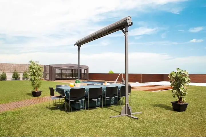 Abri de terrasse sur pied central dont une seule pente est déployée, au-dessus d’une table de jardin