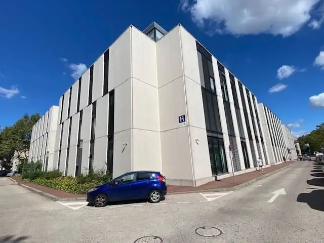 Angle du pavillon H, ses façades claires équipées de brise-soleil orientables