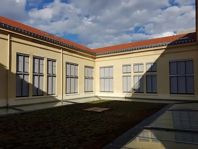 Cour des Archives municipales de Lyon : stores enrouleurs extérieurs gris baissés sur deux façades