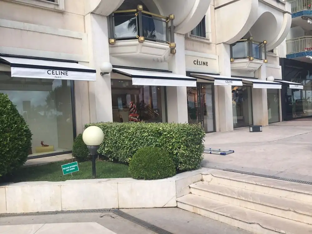 Boutique Celine sur la Croisette, à Cannes : vitrines abritées par des stores blancs à lambrequin noir