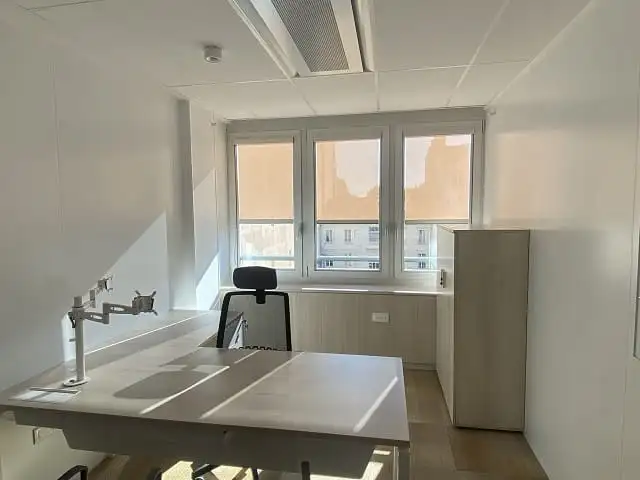 Bureau individuel du siège de Descours & Cabaud : trois stores enrouleurs beiges baissés à mi-hauteur
