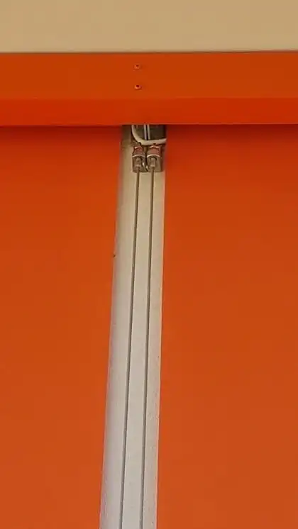 Toile orange d’un store extérieur et son câble inox de guidage, à l’hôpital de Hauteville-Lompnes