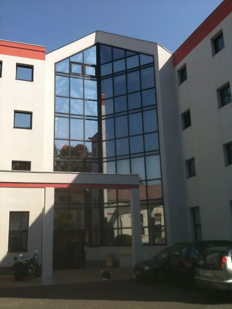 Cage vitrée d’un bâtiment du domaine universitaire de Villeurbanne, vitrages traités par films solaires