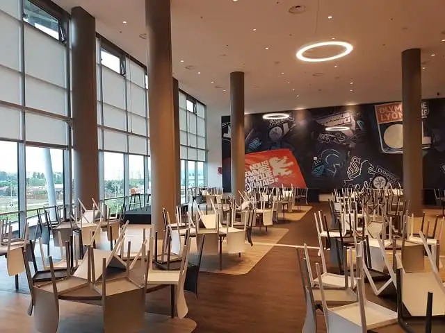 Stores enrouleurs baissés devant les grandes baies vitrées du salon du Groupama Stadium