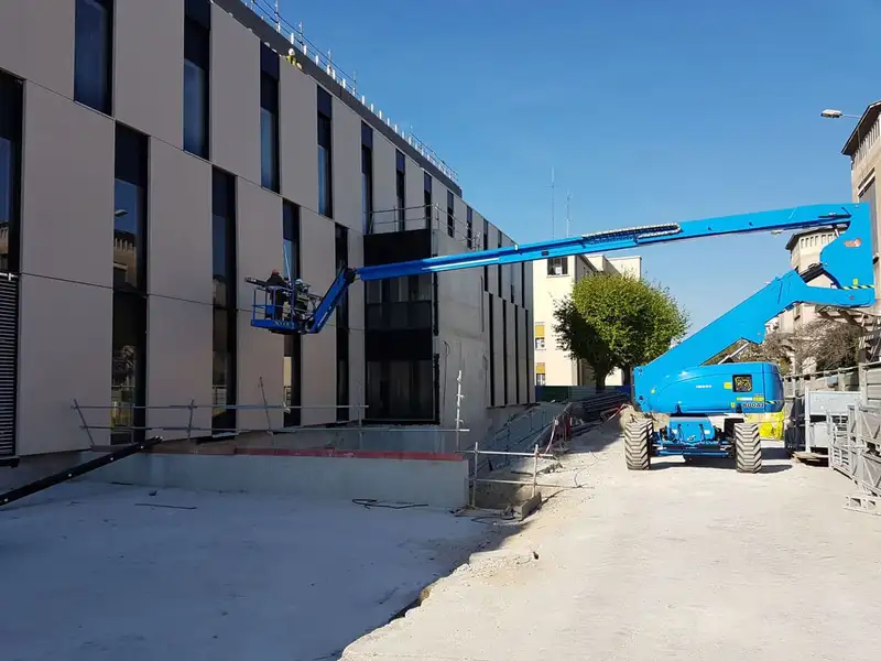 Nacelle élévatrice au pied d’une façade du pavillon H, pendant le chantier