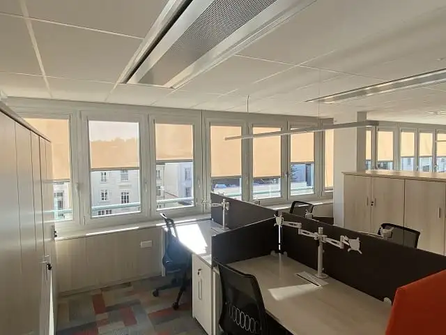 Plateau de bureaux du siège de Descours & Cabaud : stores enrouleurs beiges à demi baissés devant chaque fenêtre