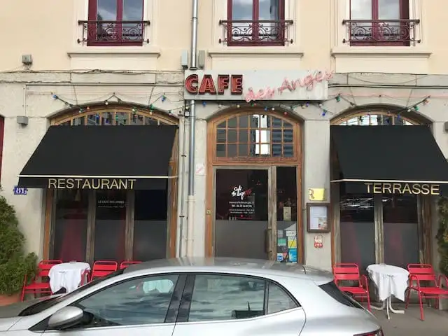 Façade d’un café-restaurant : deux bannettes noires lettrées « Restaurant » et « Terrasse »