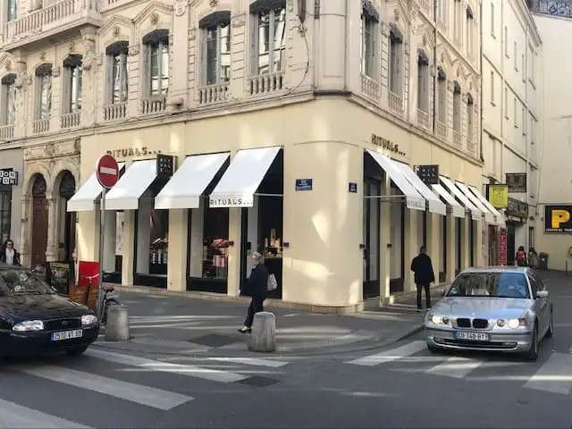 Boutique Rituals à l’angle d’un carrefour lyonnais, vitrines abritées par des bannettes blanches à lettrage