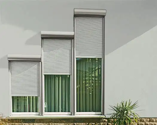Trois fenêtres équipées de volets roulants de rénovation : coffres et coulisses gris clair posés sur la façade